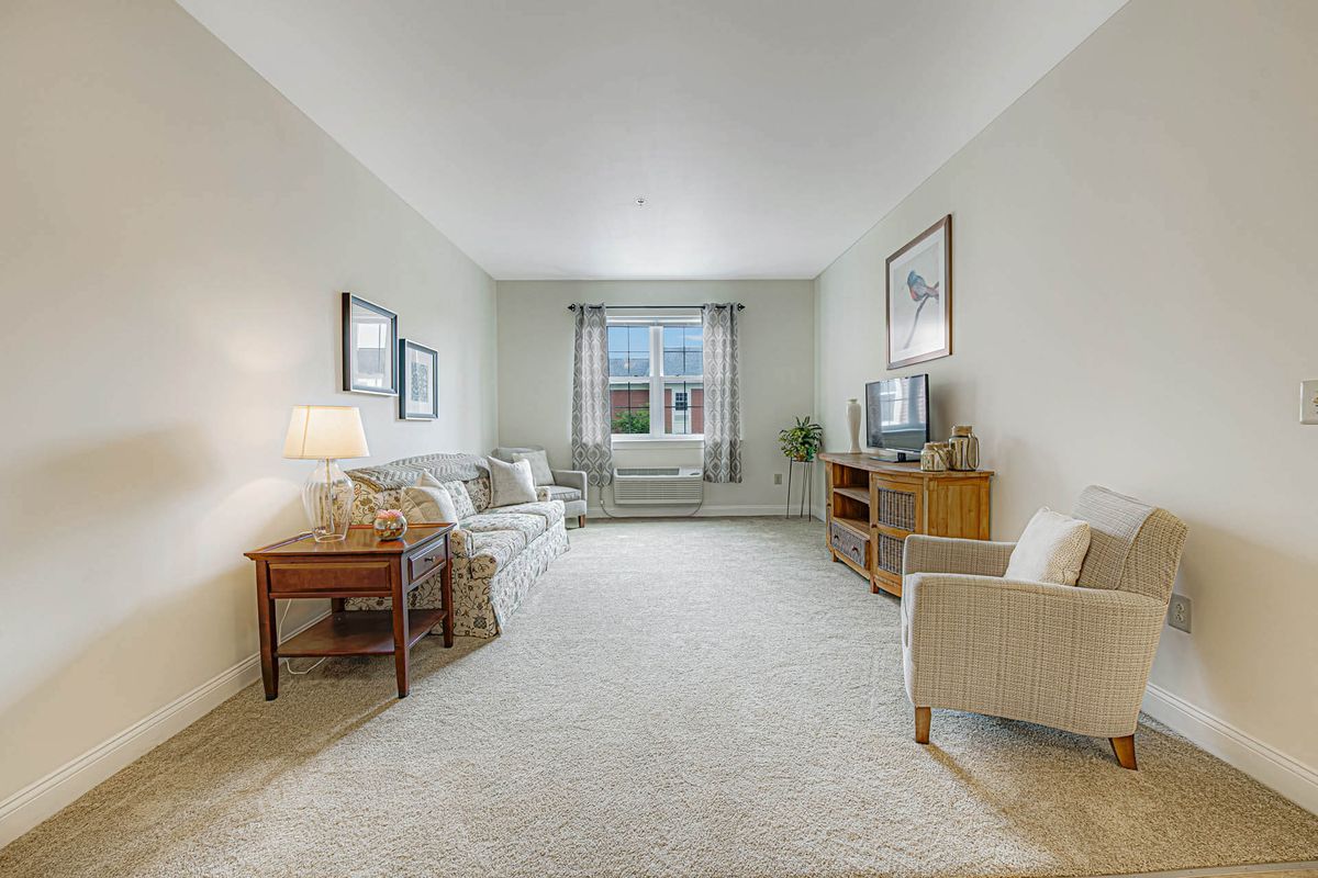 A well-lit living room with comfortable seating and a television.