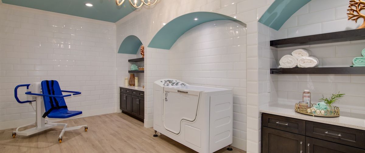 A stylish bathroom featuring a walk-in tub with white tiles and blue arch accents.