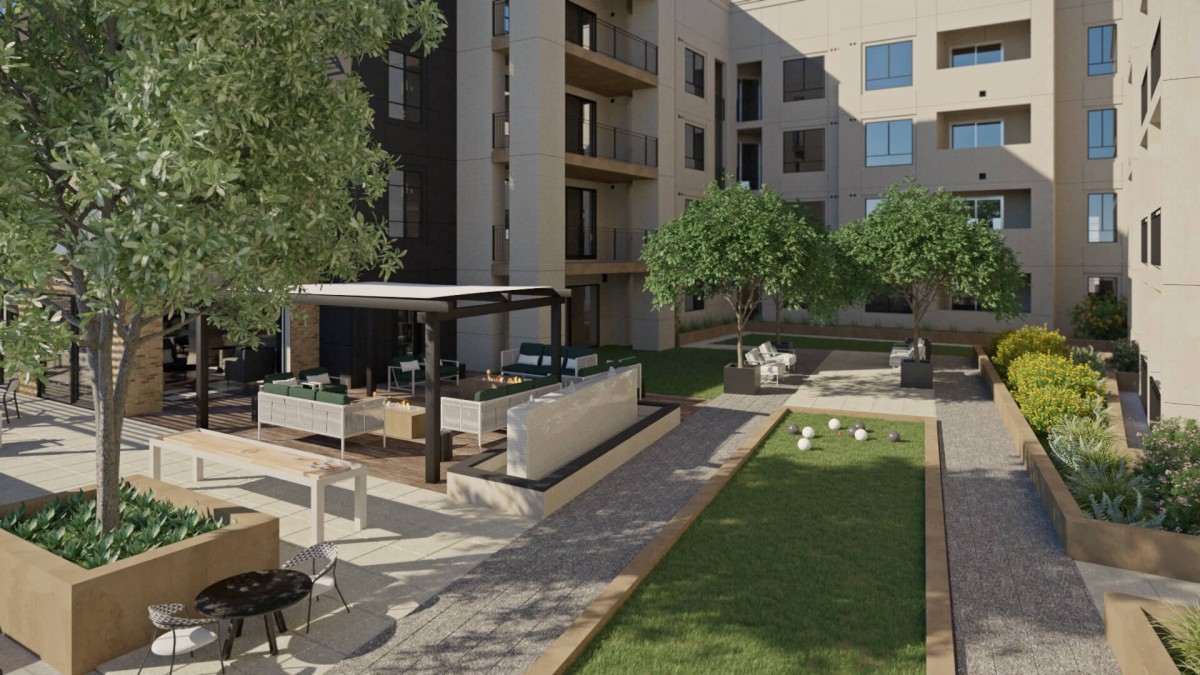 A modern apartment courtyard with landscaped greenery and outdoor seating.