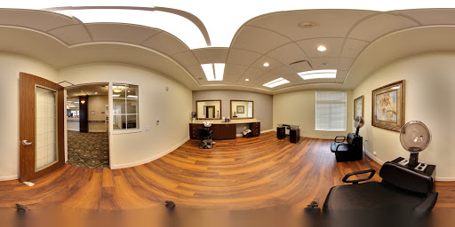A modern office interior featuring wooden flooring and ample natural light.