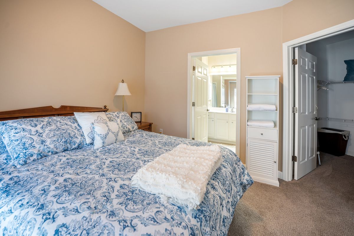 A cozy bedroom with a neatly made bed and connected bathroom.