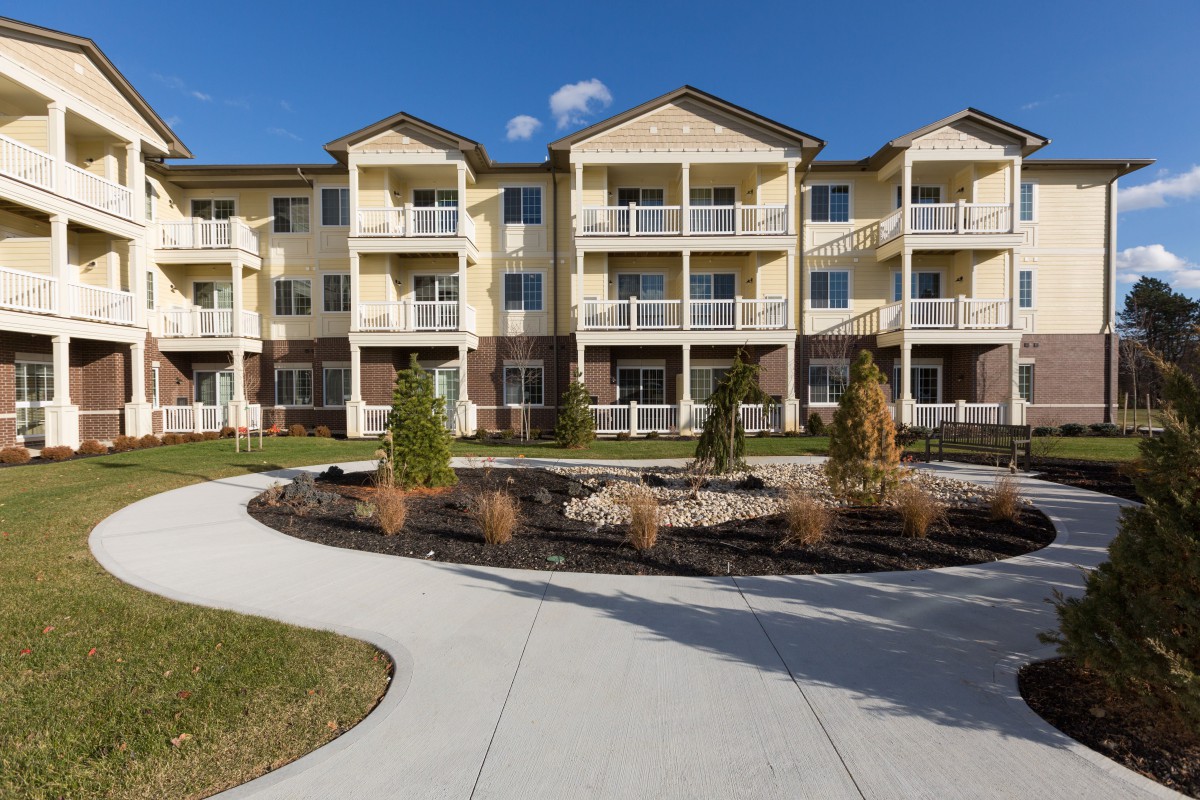 A modern apartment complex with landscaped grounds and multiple balconies.