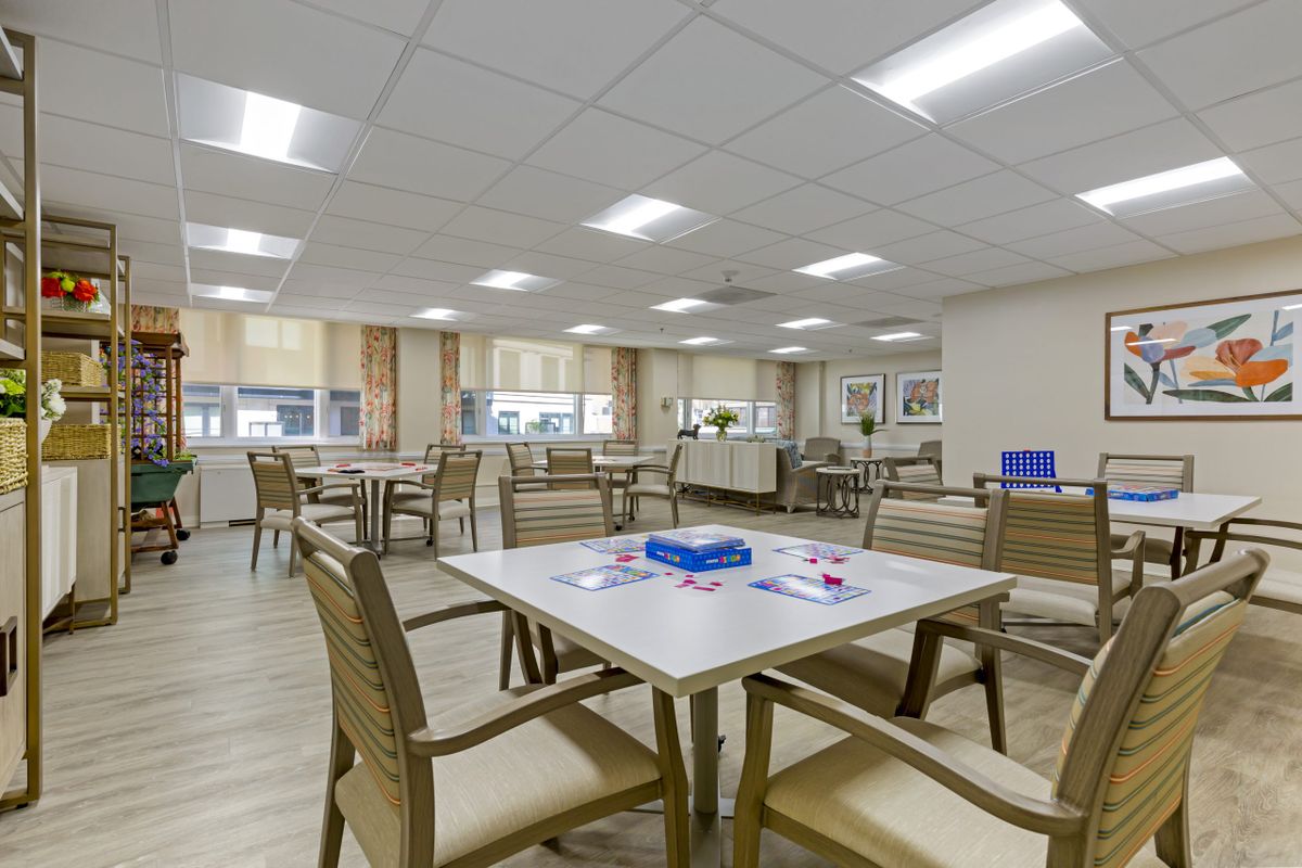 A modern and well-lit dining area with neatly arranged tables and chairs.