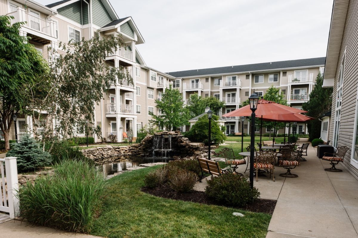 A serene courtyard with a garden and gazebo surrounded by apartment buildings.