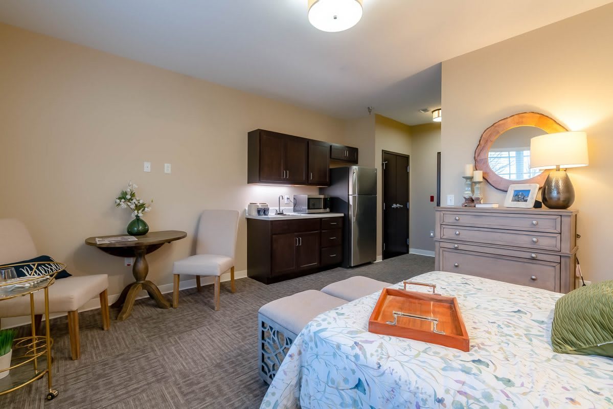 A cozy studio room featuring a kitchenette and a comfortable bed, complemented by modern decor.