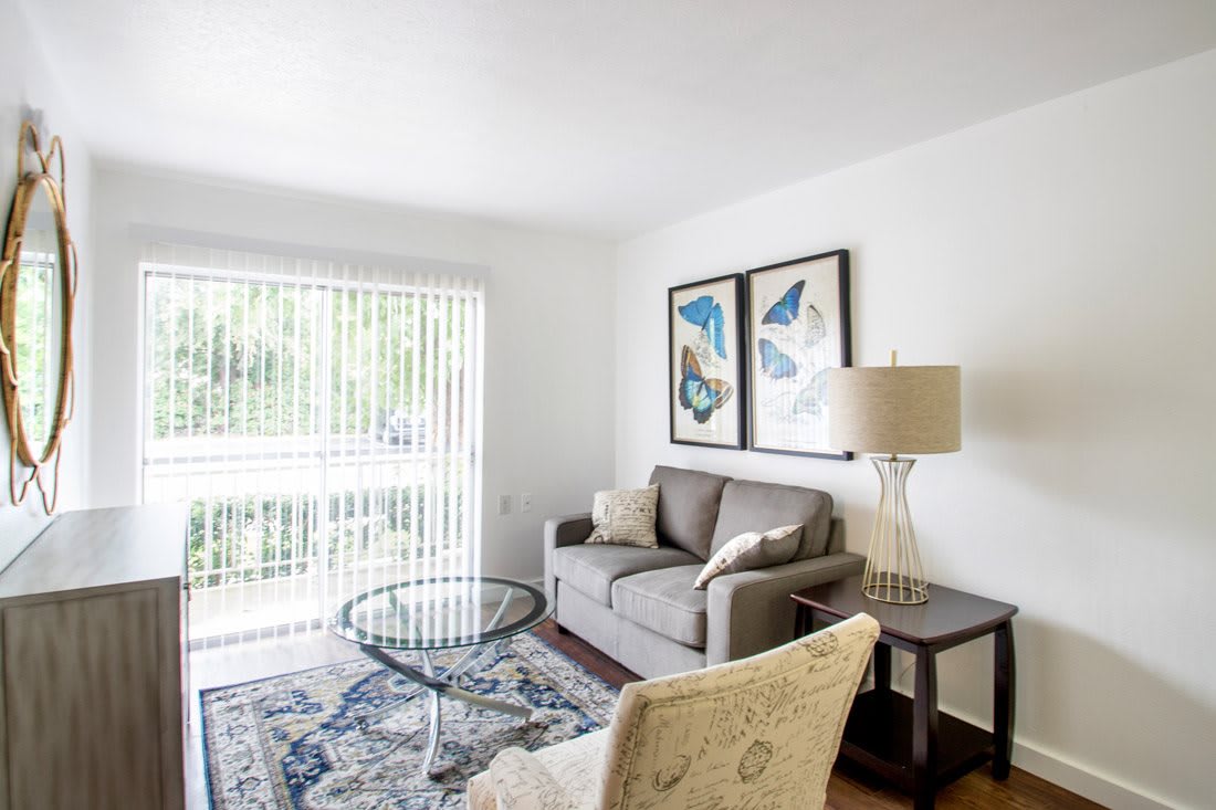 A modern living room with a sofa, glass coffee table, and tasteful artwork.