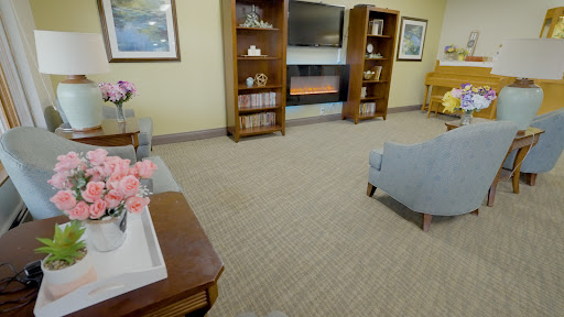 A cozy living room setup featuring shelves, a television, and comfortable seating.