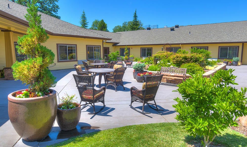 A sunny patio with comfortable seating and lush greenery.