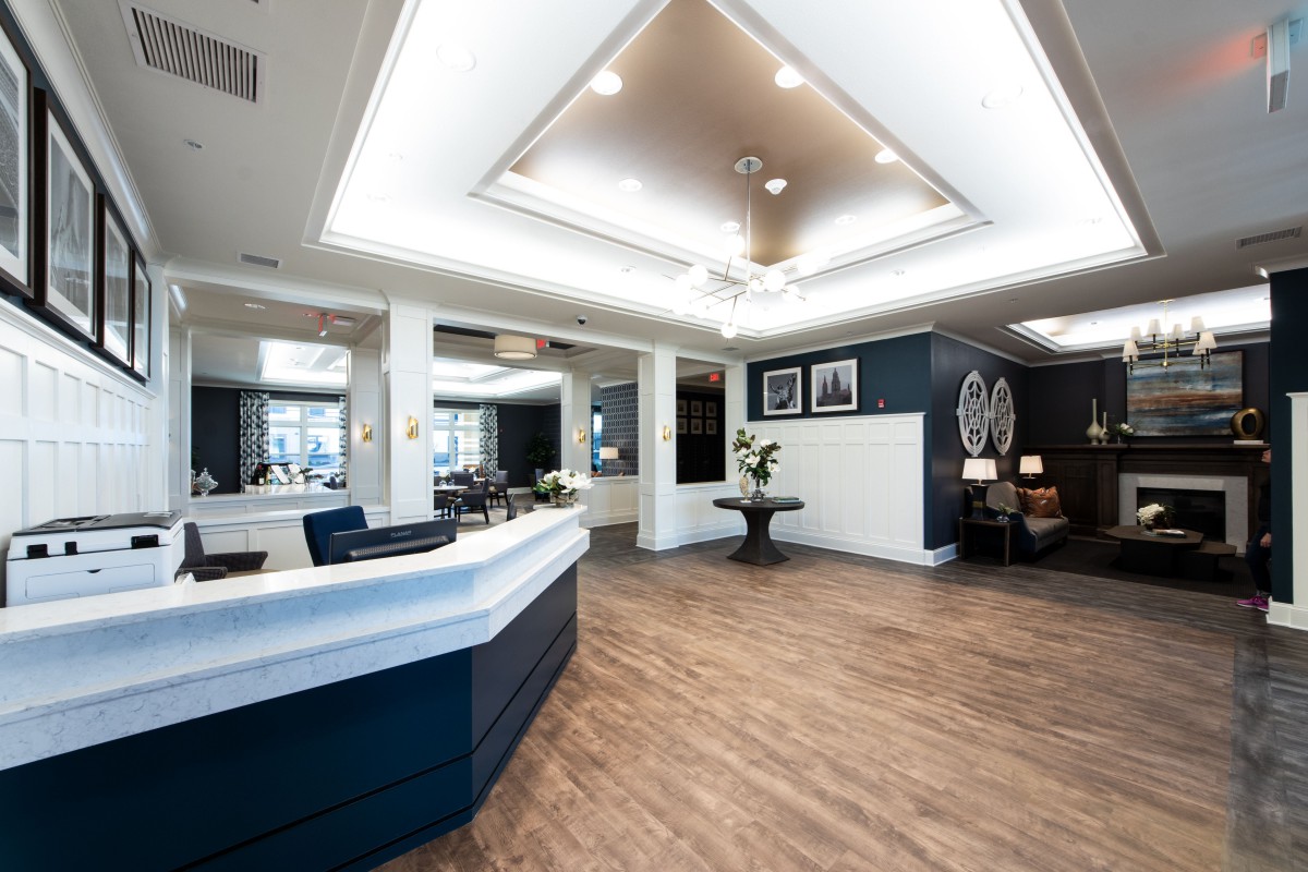 A modern reception area with sleek design, featuring wooden floors and ceiling lights.