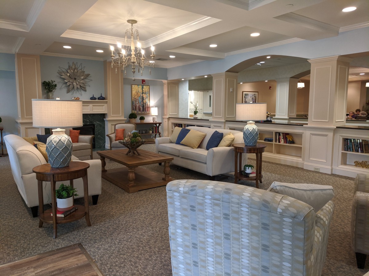 A cozy and elegantly decorated living room with comfortable seating, a central coffee table, and soft lighting.