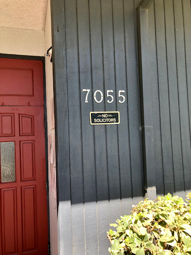 The entrance of a building featuring the address number 7055.