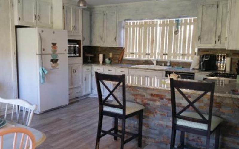 A well-lit kitchen interior with modern appliances and seating.