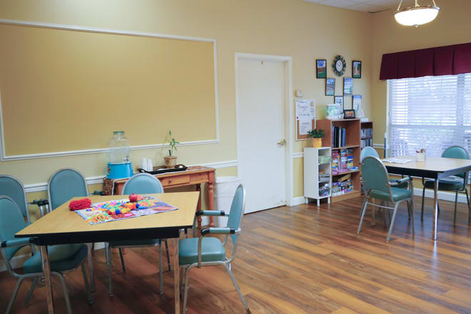 A classroom setting with tables, chairs, and educational materials present.