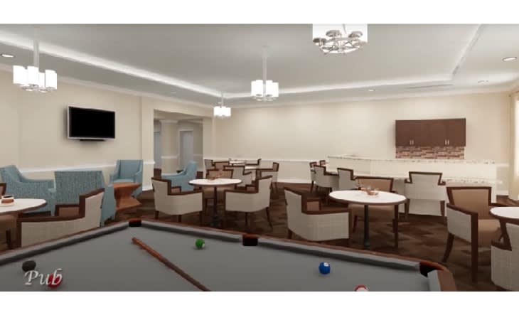 A spacious recreation room featuring a pool table and several tables with chairs, illuminated by modern lighting fixtures.