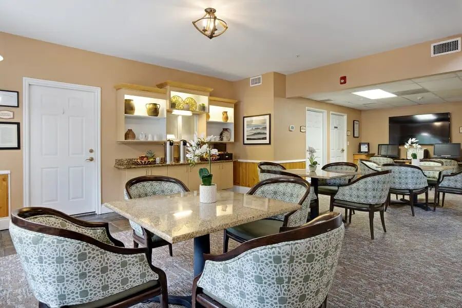 A cozy dining area with tables and chairs arranged neatly, featuring warm lighting and tasteful decor.