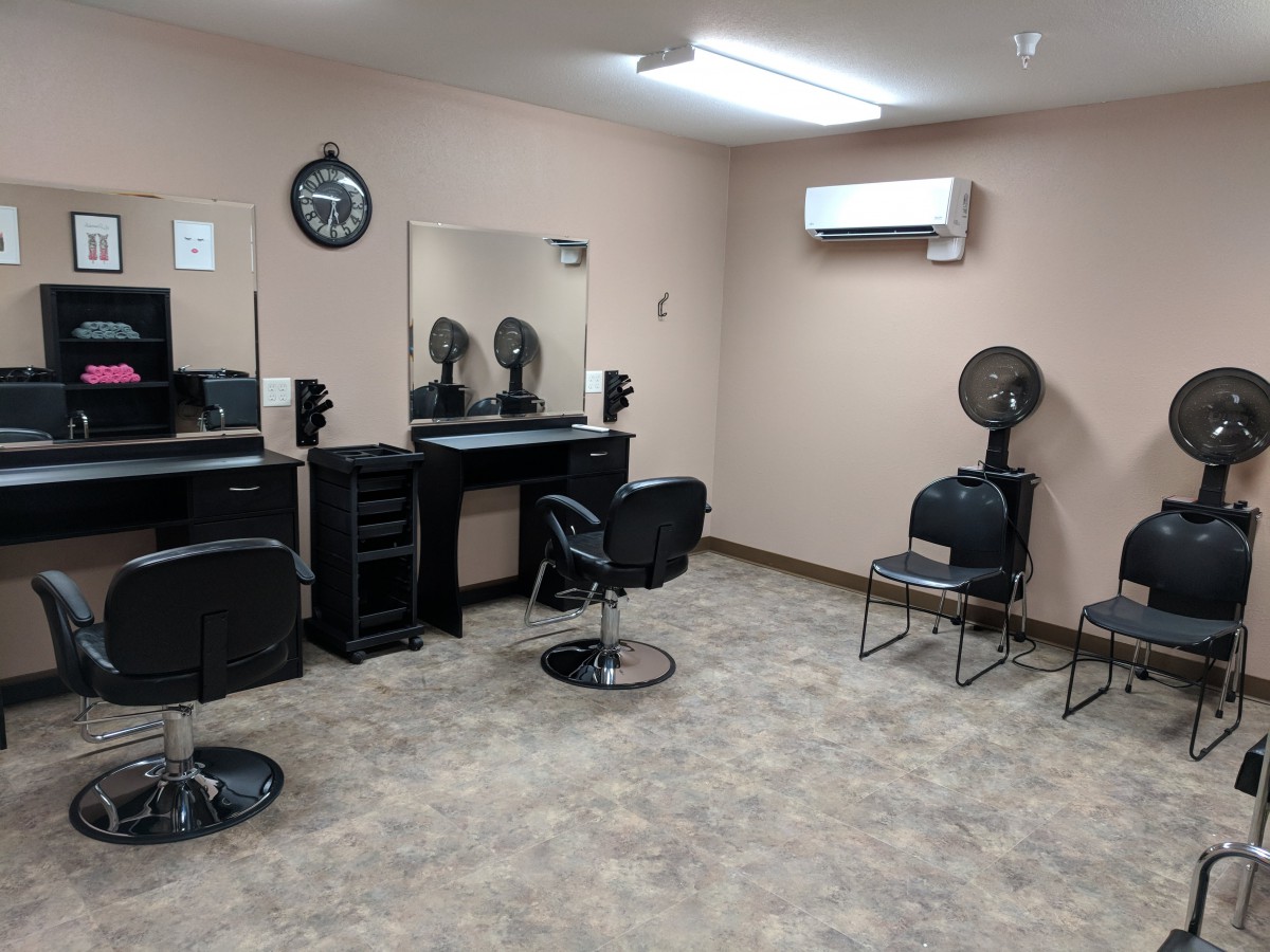 A tidy and organized hair salon with styling stations and a small waiting area.