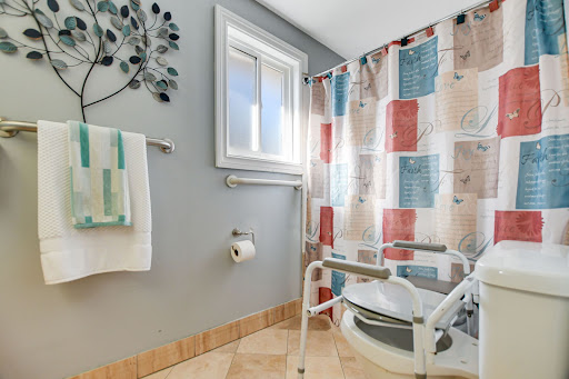 A well-designed accessible bathroom featuring grab bars and a colorful shower curtain.