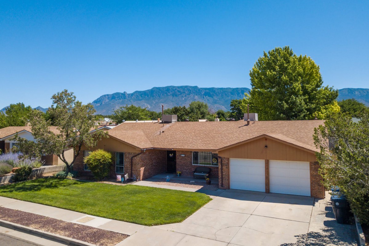 A suburban house with a well-maintained front yard and a view of the mountains in the background.