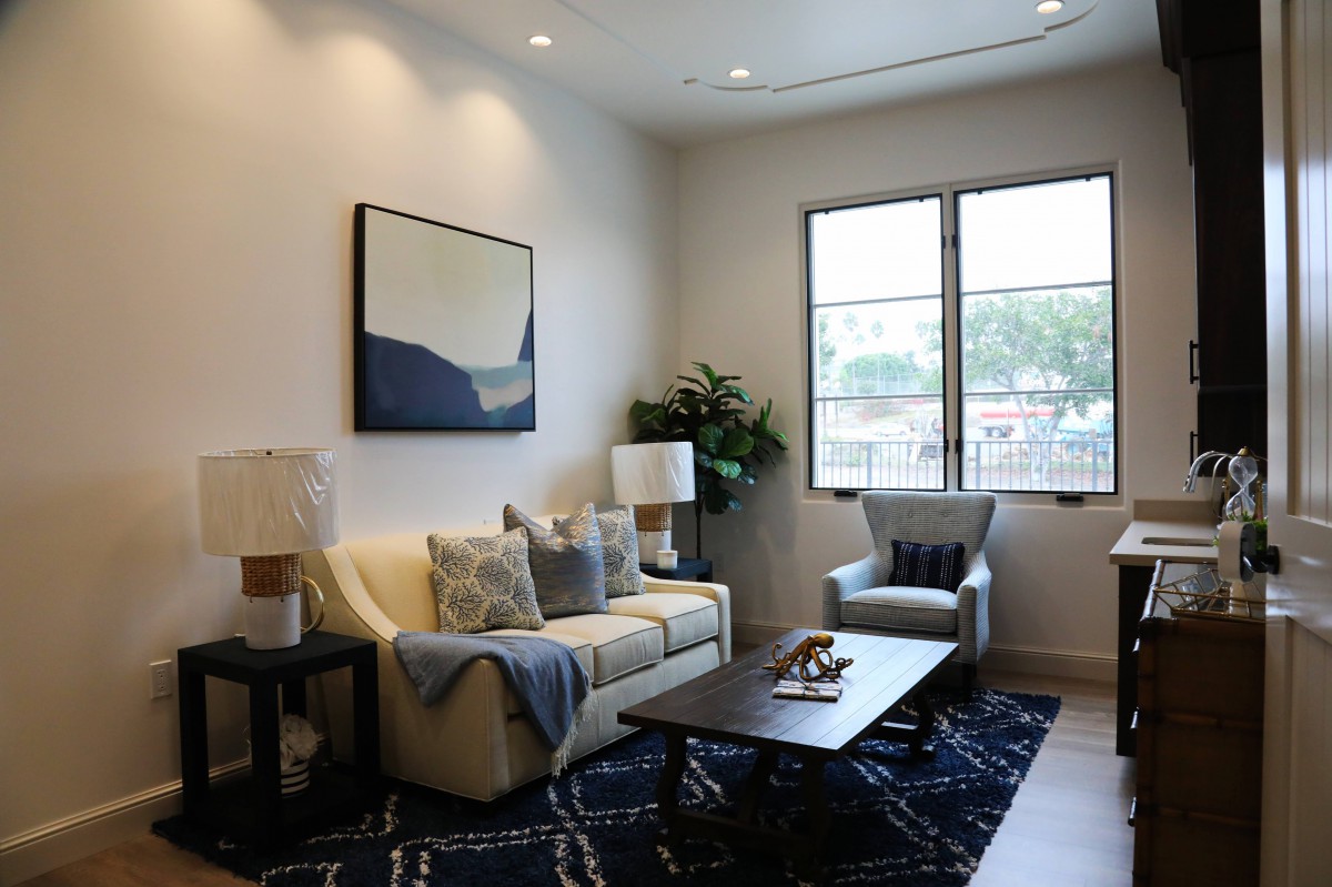 A cozy living room with modern furnishings, featuring a sofa, armchair, and coffee table.