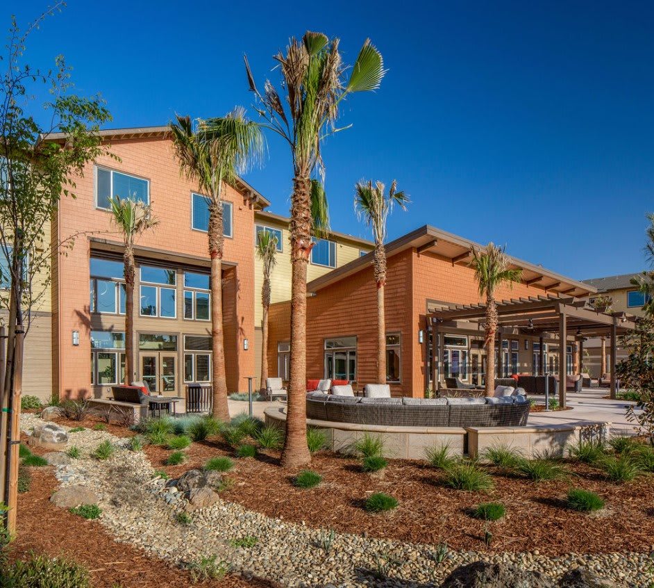 A sunny view of a resort with palm trees and landscaped surroundings.