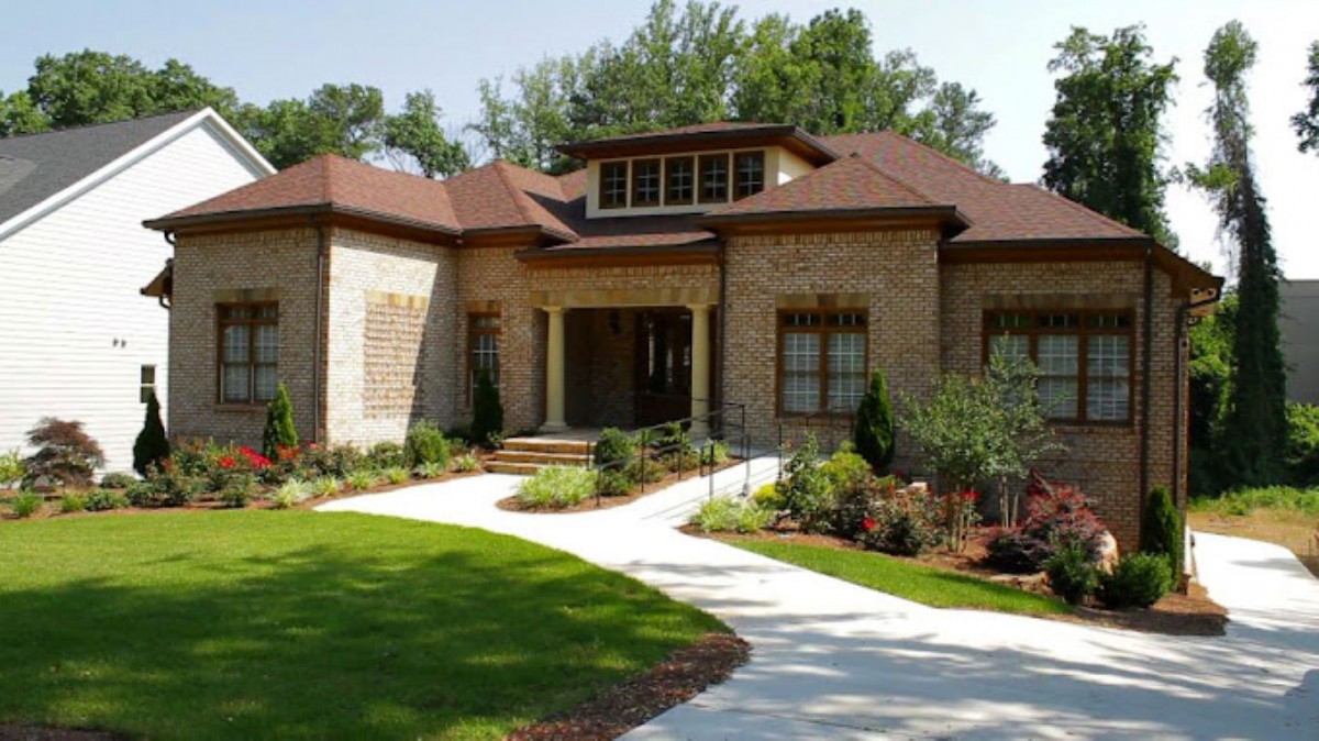 A beautiful brick house with a well-maintained garden and curved pathway.