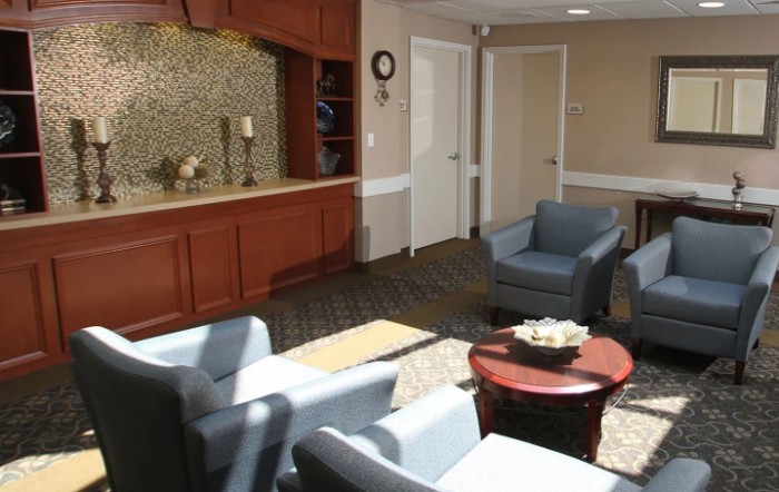 A comfortable lobby with seating area, featuring chairs and a table in a warmly decorated space.