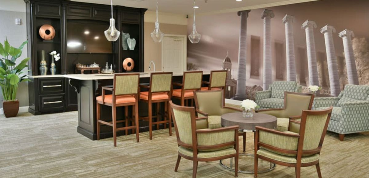 A modern lounge area featuring a bar with high stools and comfortable seating.