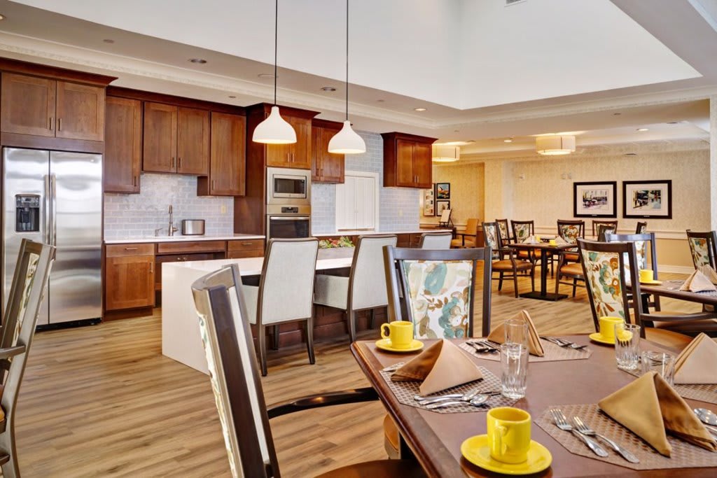 A modern kitchen and dining area with wooden cabinets and pendant lighting.