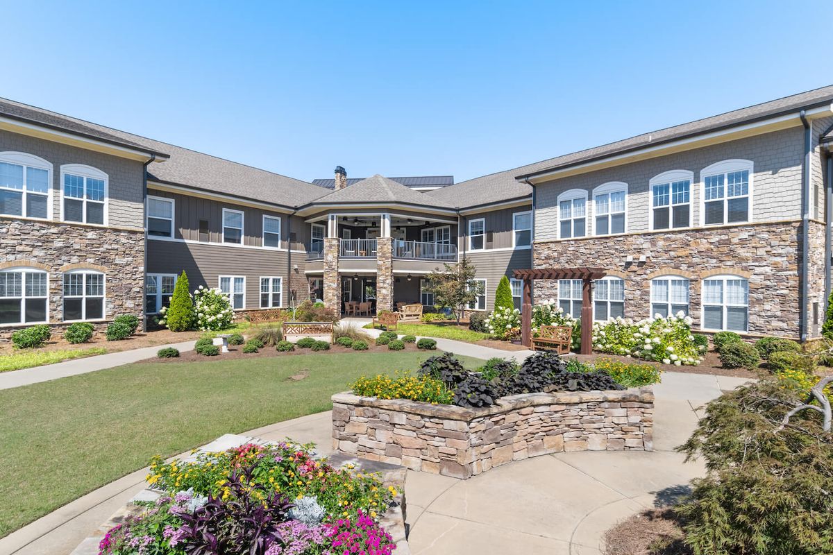 A beautifully landscaped residential courtyard with a modern building in the background.