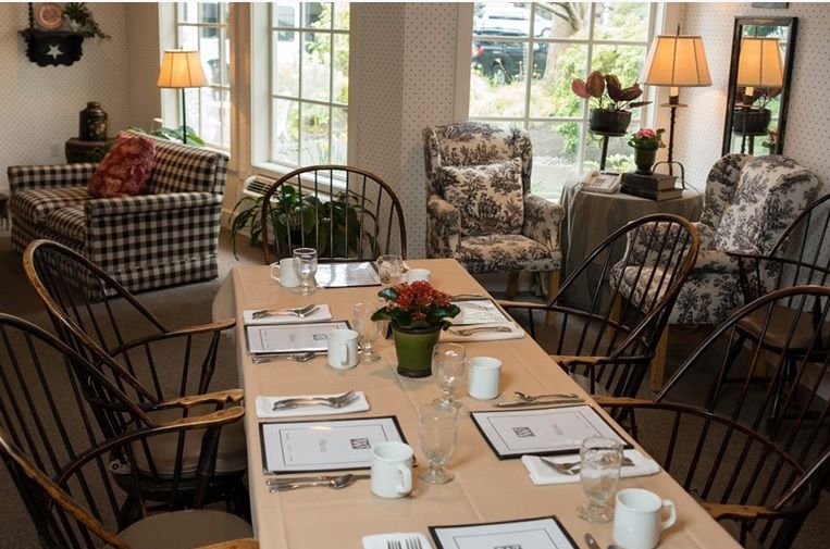 A cozy dining space with a neatly set table and comfortable seating.