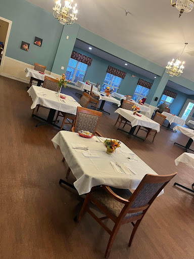 A spacious dining area set with neatly covered tables, awaiting guests.