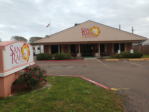 A view of a restaurant with a prominent sign, set against a cloudy sky.