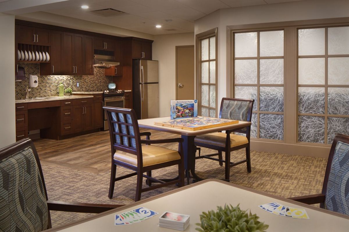A modern kitchen and dining area with a table and chairs, featuring stylish interior design.