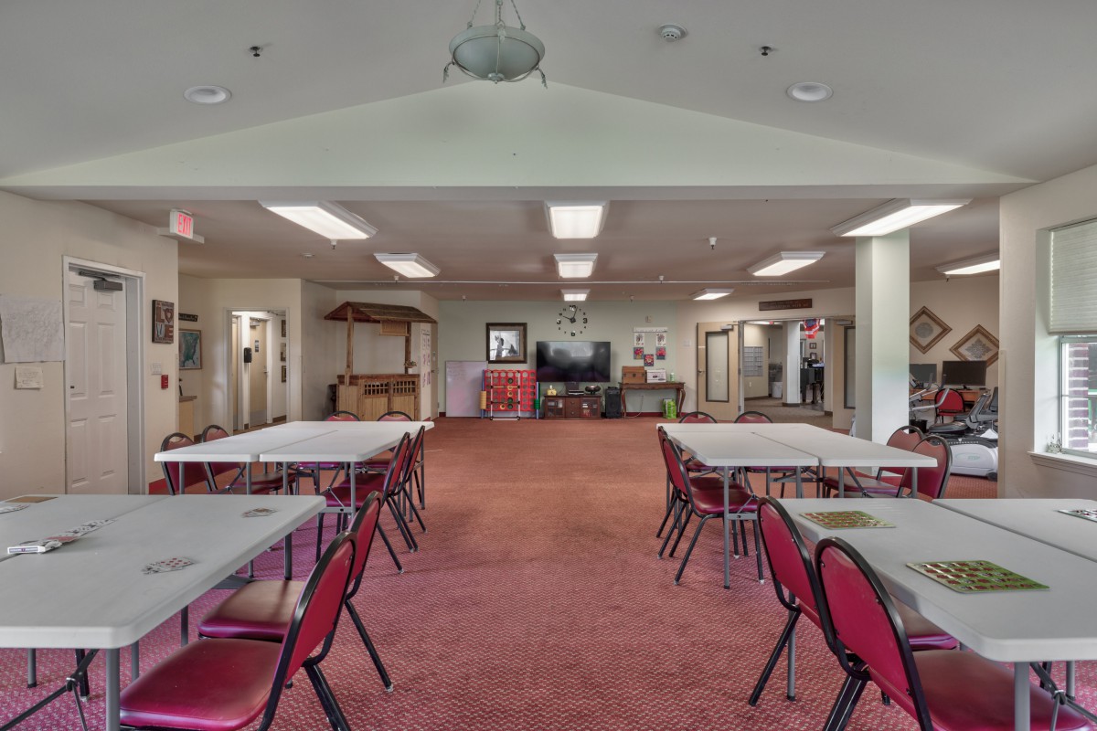 A spacious meeting room with tables and chairs arranged for a conference or event.