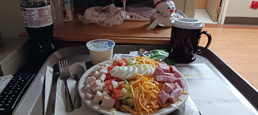A colorful salad platter featuring turkey, ham, cheese, and fresh vegetables.
