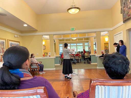A community gathering where a speaker engages with the audience in a warm and inviting setting.