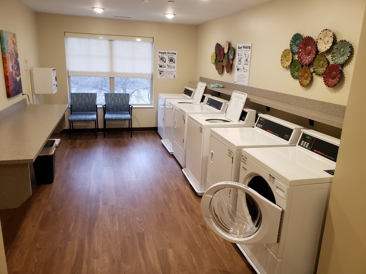 A tidy laundry room with several washing machines and dryers.