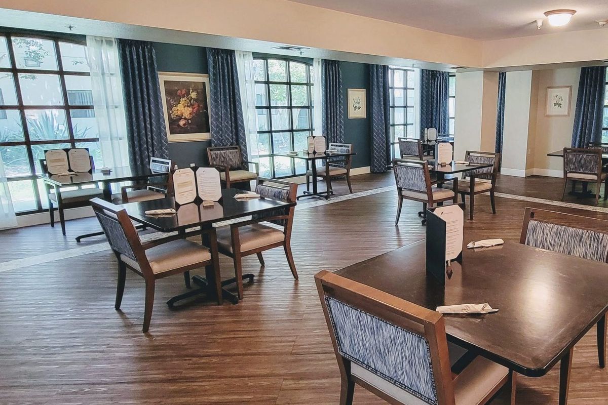 An empty restaurant dining area with neatly arranged tables and chairs.
