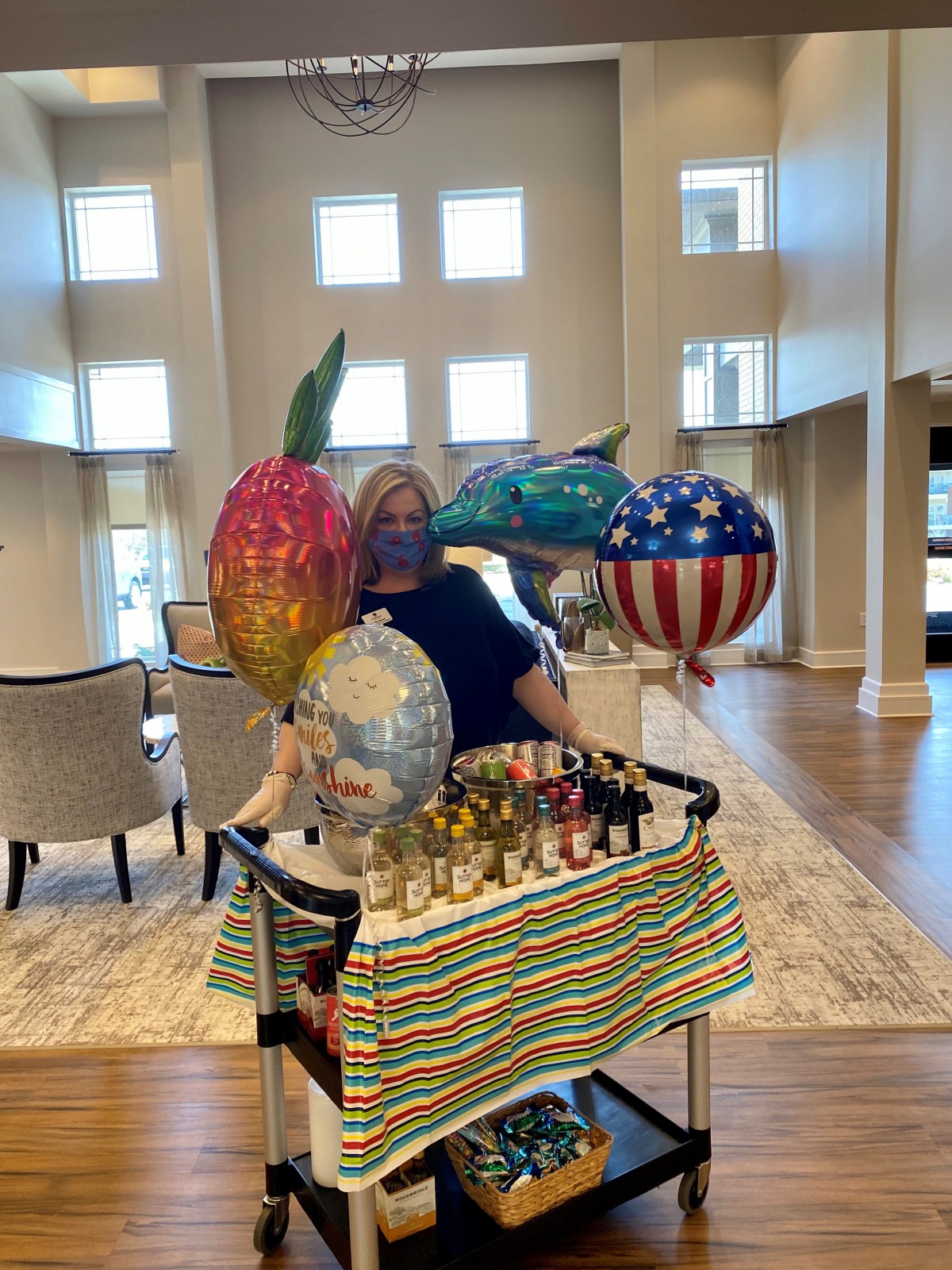 A colorful arrangement of balloons and decorations on a cart indoors, ready for a celebration.