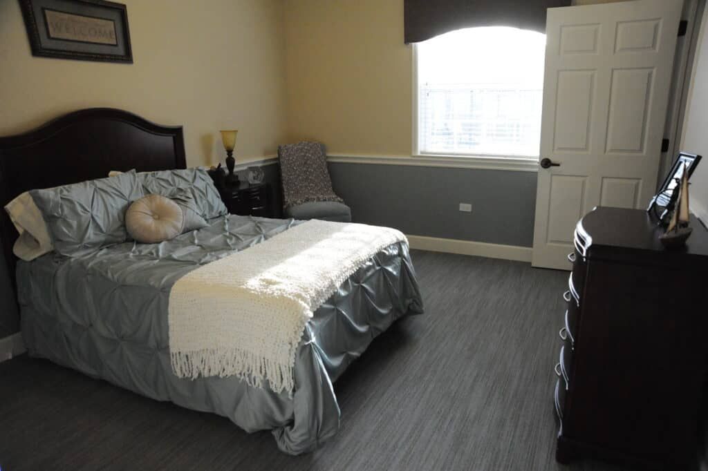 A well-lit bedroom with a neatly made bed and stylish decor.