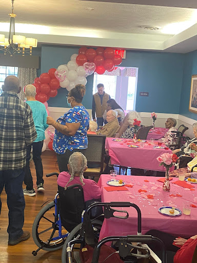 A joyful gathering at the community center, decorated with balloons and festive colors, celebrating together.