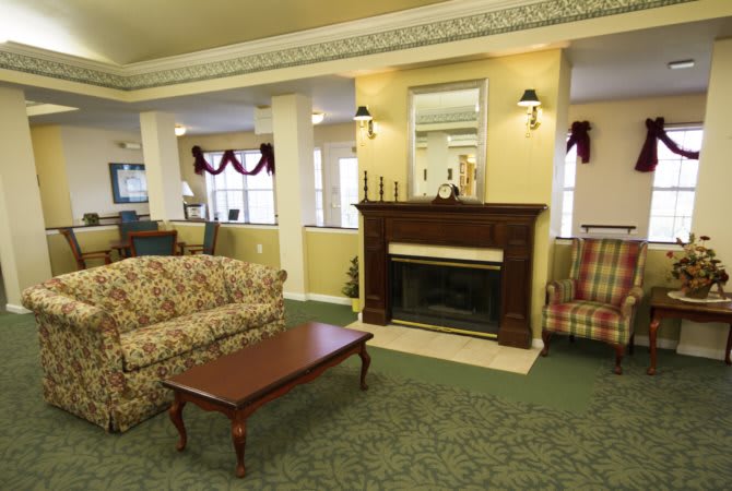 A cozy living room with a fireplace, comfortable sofas, and a wooden coffee table.