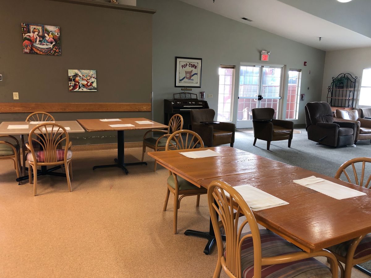 An empty cafe dining area with tables and chairs, featuring a cozy interior design.