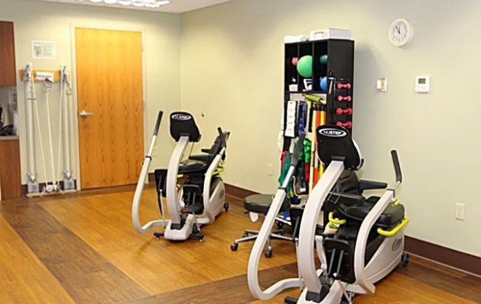 A small fitness room equipped with exercise machines and various workout accessories.