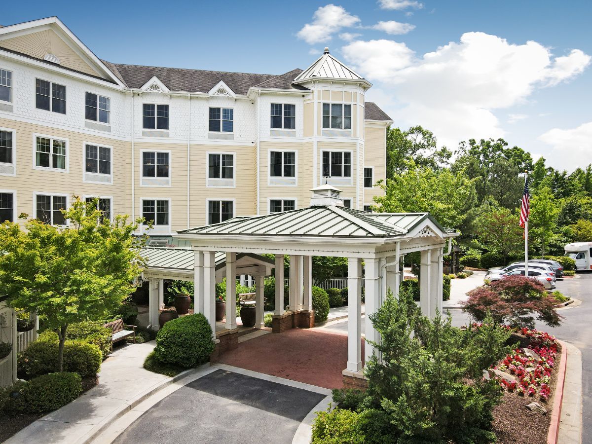 A hotel with a grand entrance surrounded by lush greenery.