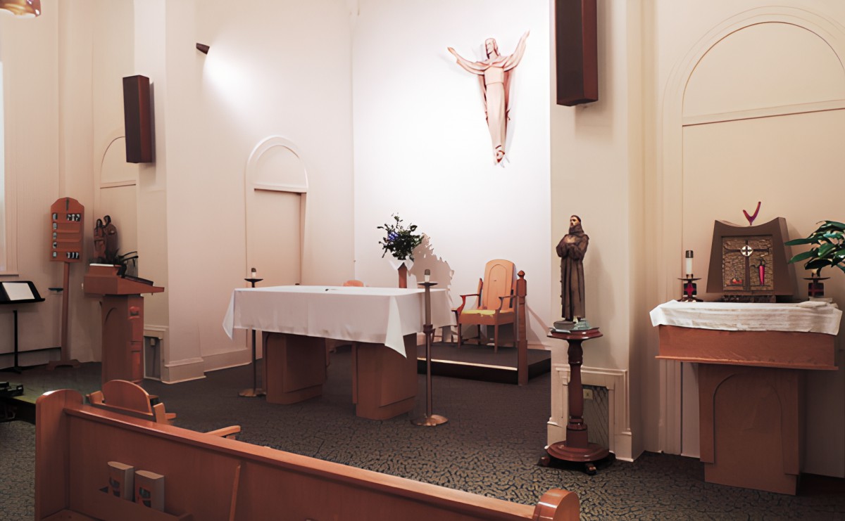 An interior view of a church showing the altar, crucifix, and religious statues.