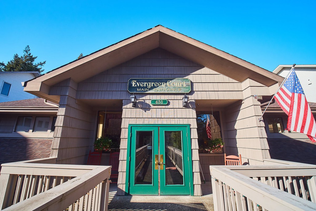 The entrance of the Evergreen Inn with green double doors and a wooden exterior.