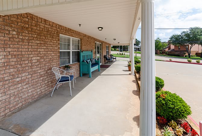 A cozy front porch with outdoor seating and neatly maintained landscaping.