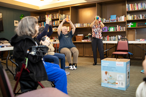 Seniors participating in a group exercise session, focusing on movement and wellness in a library setting.