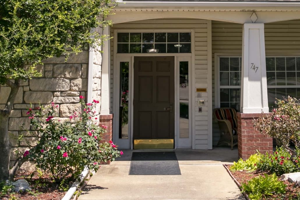 A welcoming front entrance of a house surrounded by well-maintained landscaping.